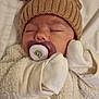 baby, sleeping, pacifier, hat, reindeer_hat, mittens, white_clothing, fluffy, cute, infant, face, nose, closed_eyes, soft_texture, bear_patch, cozy, indoors, child, newborn, cute_outfit