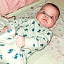 Bayley joined the competition — help win amazing prizes! baby, infant, onesie, bed, blue_flower_pattern, hand, foot, face, expression, curious, surprised, skin, blanket, sleepwear, lying_down, indoors, child, cute, pajamas, person