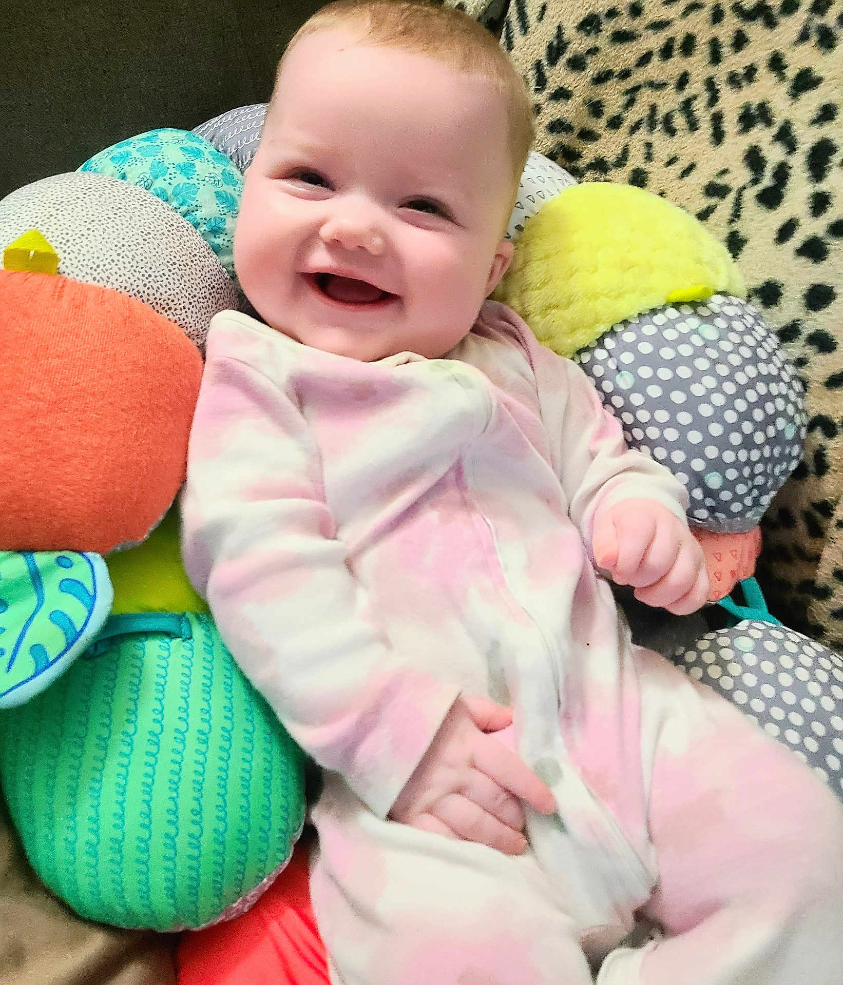 Bayley joined the competition — help win amazing prizes! baby, smile, onesie, plush_toy, cushion, pattern, happy, child, indoor, cute, infant, soft_toy, face, person, colorful, comfort, relax, cheerful, cozy, portrait