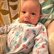 Jovi joined the competition — help win amazing prizes! baby, infant, onesie, blanket, cozy, cute, sleepwear, patterned, animal_print, soft_texture, child, portrait, indoors, resting, newborn, young_child, warm, comfort, face, expressive_eyes