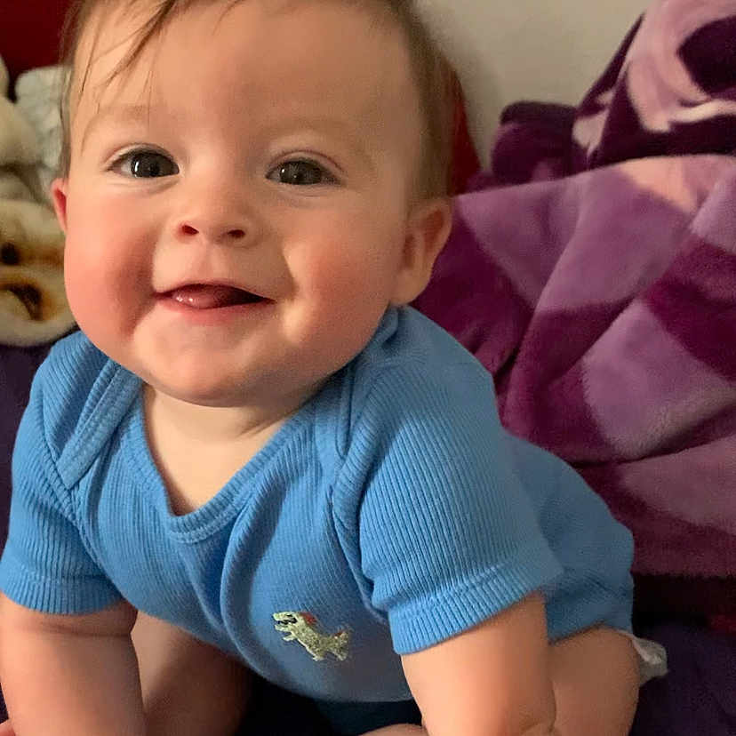 Ace joined the competition — help win amazing prizes! baby, blanket, blue_shirt, cheerful, child, couch, cute, face, hair, happy, head, indoor, infant, person, portrait, sitting, skin, smiling, toddler, young_child