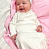 baby, infant, smiling, pink_bow, blanket, white_outfit, headband, lying_down, happy, portrait, child, cute, soft_texture, indoors, cozy, social_media, story, screen, mobile_interface, closeup