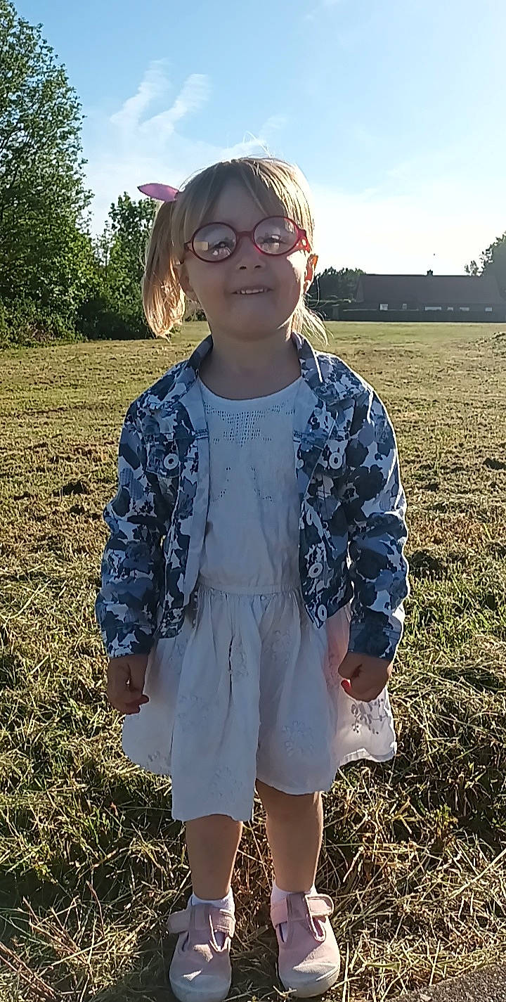 Maeva participe au concours pour gagner de l'argent avec cette photo : cool, day_dress, eyewear, fun, grass, grassland, hair, hairstyle, happy, joy, light, people_in_nature, person, plant, sky, sleeve, smile, summer, sunlight, toddler