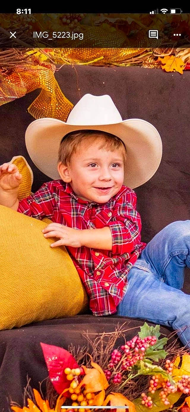 Karson is registered to the contest to win money with this photo: child, cowboy_hat, event, fun, happy, hat, headgear, holiday, jeans, joy, leisure, people, person, photograph, plaid, plant, sitting, smile, sun_hat, tartan