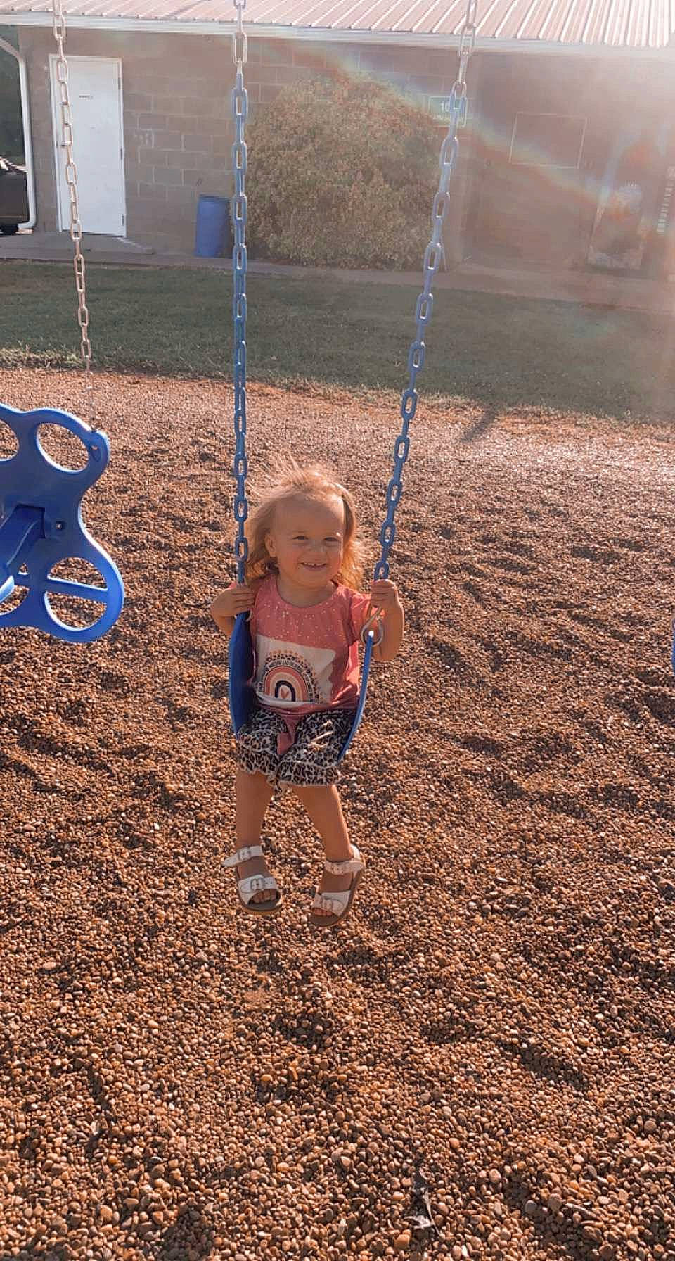 Madalynn is registered to the contest to win money with this photo: baby, child, city, electric_blue, fun, grass, happy, human_body, joy, landscape, leisure, outdoor_play_equipment, people_in_nature, person, play, playground, recreation, soil, swing, t_shirt