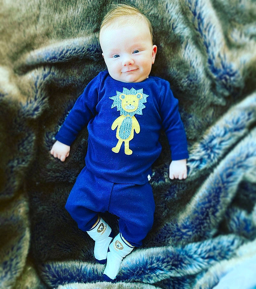 Davis is registered to the contest to win money with this photo: azure, baby_toddler_clothing, child, couch, electric_blue, eye, happy, head, iris, organ, outerwear, person, photograph, purple, skin, sleeve, smile, t_shirt, textile, toddler