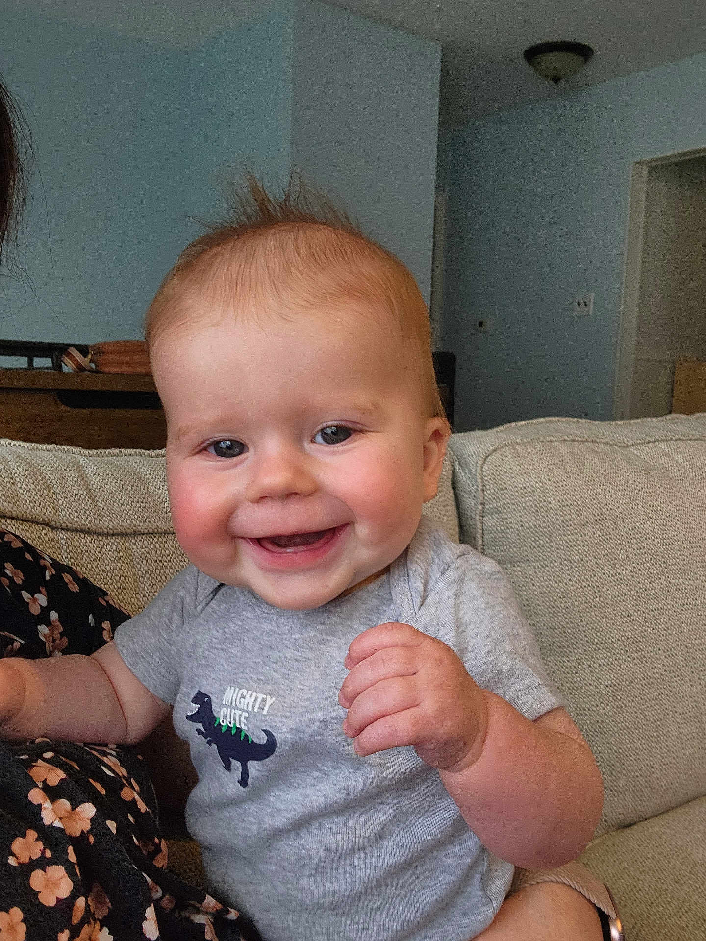 Elijah is registered to the contest to win money with this photo: baby, smiling, child, indoor, couch, clothing, dinosaur_graphic, grey_shirt, happy, portrait, toddler, furniture, home, person, cute, infant, sitting, hand, face, hair