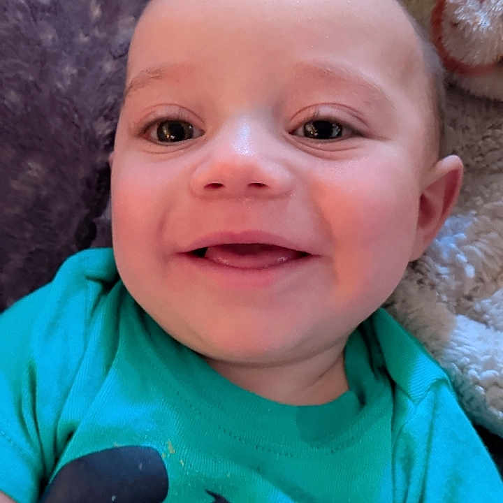 Lazarent is registered to the contest to win money with this photo: baby, blanket, blue_shirt, child, closeup, cozy, cute, face, fish_graphic, happy, head, indoors, infant, lying_down, portrait, skin, smiling, texture, tshirt, young_child