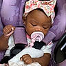 Blessyn is registered to the contest to win money with this photo: baby, infant, pacifier, car_seat, purple, headband, floral, blanket, clothing, child, cute, sleepy, seatbelt, toddler, portrait, person, hand, soft, comfort, closeup