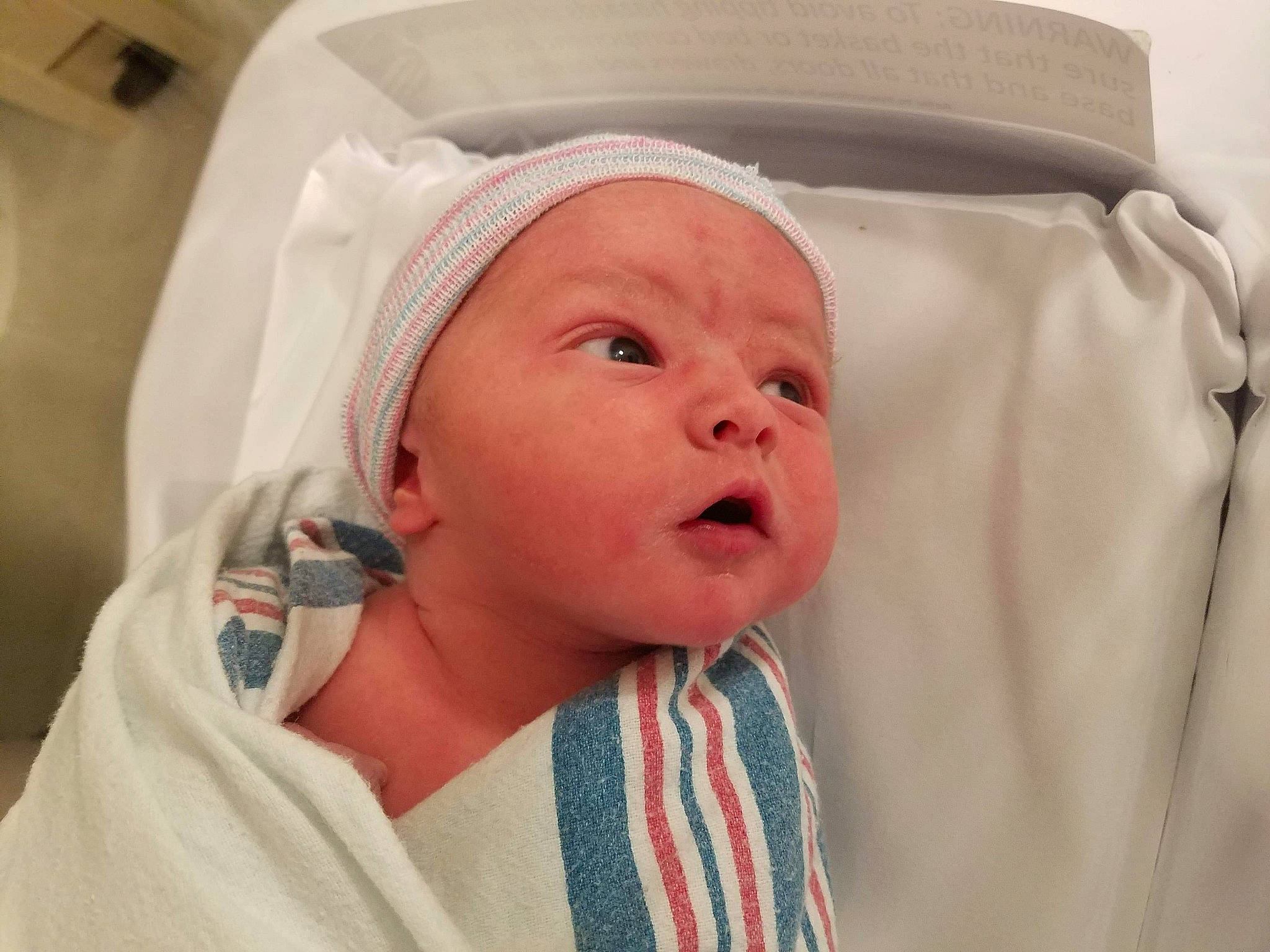 Tyler is registered to the contest to win money with this photo: baby, baby_toddler_clothing, child, chin, collar, comfort, event, eye, eyebrow, face, happy, hat, linens, mouth, nose, peach, person, room, skin, sleeve