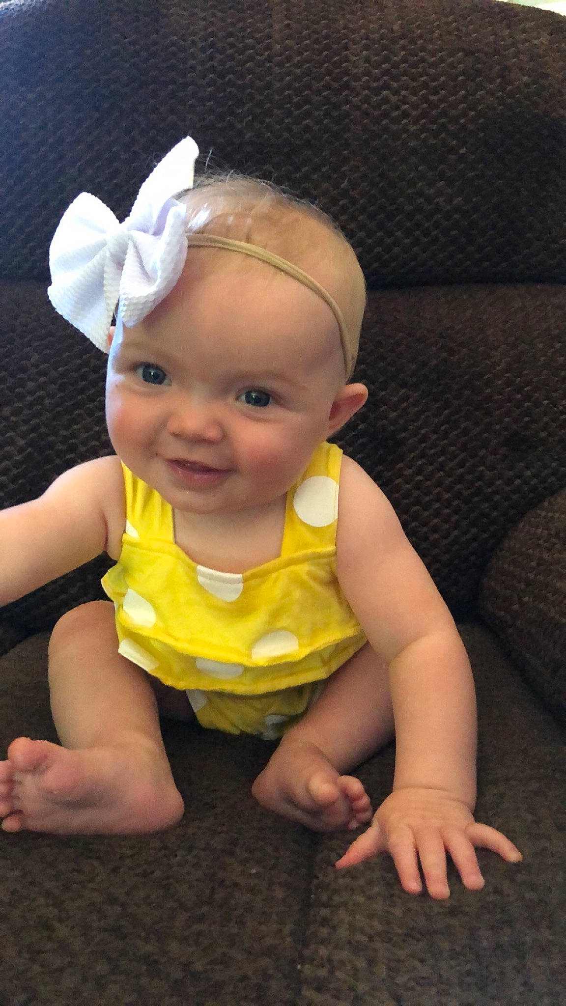Elsie is registered to the contest to win money with this photo: arm, baby, baby_toddler_clothing, cheek, child, ear, hair_accessory, head, headband, headgear, joy, person, skin, smile, toddler, tummy_time, yellow