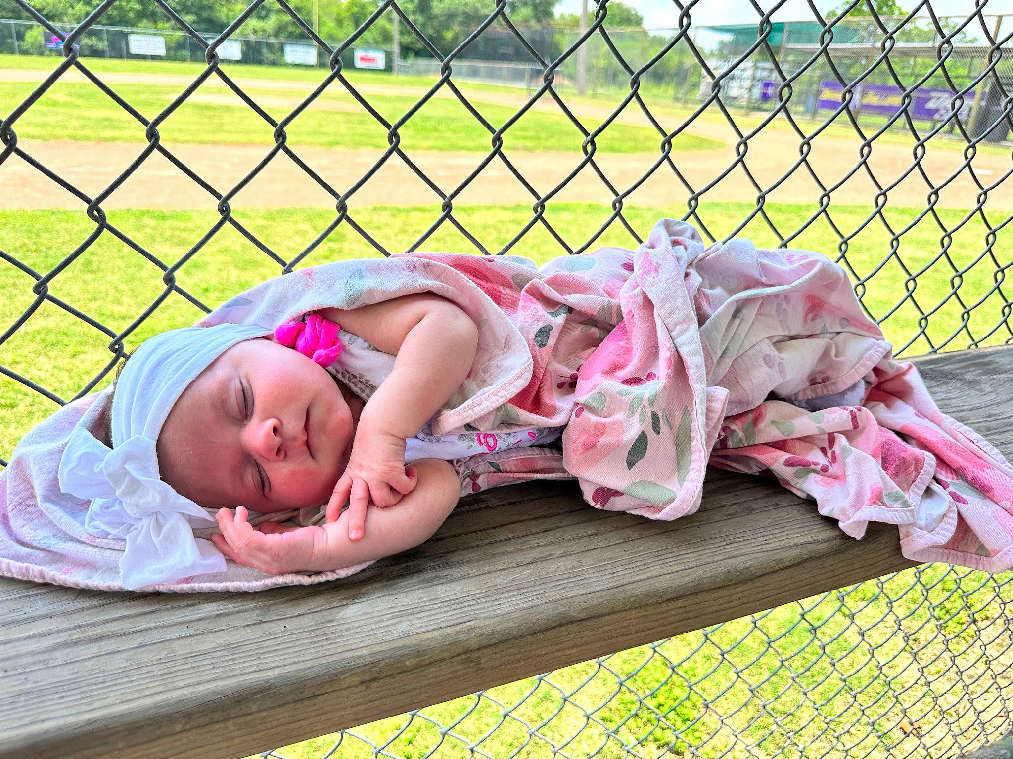 Brooklynn is registered to the contest to win money with this photo: baby, baby_toddler_clothing, child, comfort, fence, fun, grass, happy, headwear, leisure, magenta, mesh, outdoor_furniture, pattern, people_in_nature, person, pink, recreation, sitting, toddler