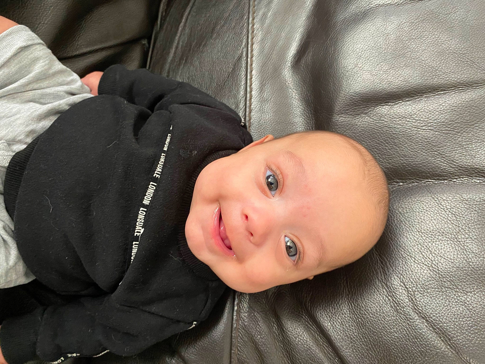 Kayden is registered to the contest to win money with this photo: baby, baby_toddler_clothing, cheek, child, comfort, flash_photography, happy, head, joy, person, portrait_photography, sitting, sleeve, smile, toddler, tree, wood