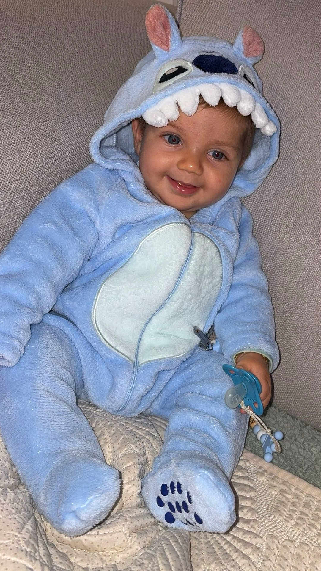 Neylan participe au concours pour gagner de l'argent avec cette photo : baby, child, smiling, blue_onesie, hood, ears, teeth, pacifier, blanket, sitting, fuzzy, cute, indoor, soft_lighting, happy, infant, clothing, face, cozy, toy