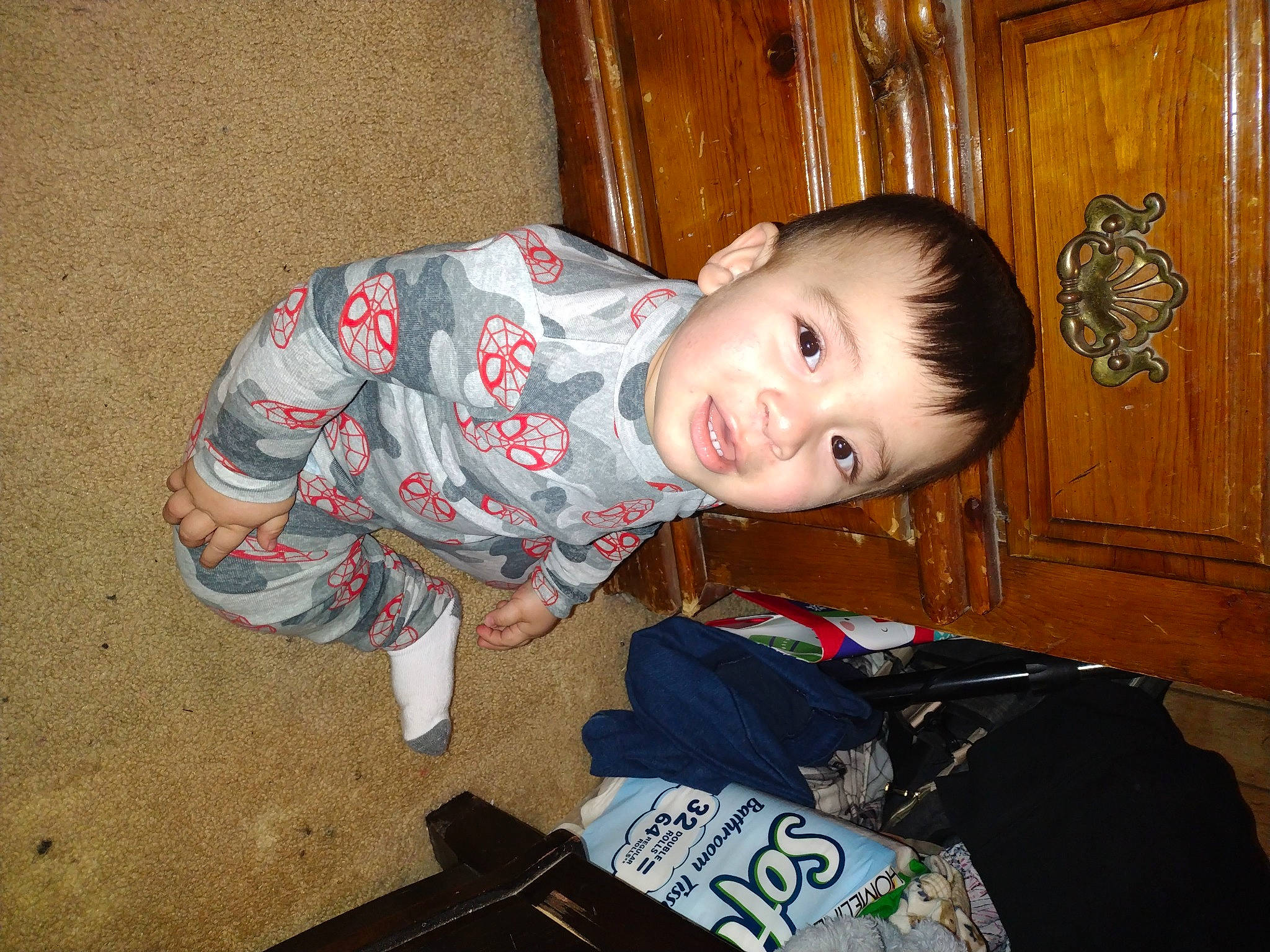 Julius is registered to the contest to win money with this photo: baby, baby_toddler_clothing, bag, cheek, child, flooring, fun, hardwood, luggage_and_bags, person, sitting, sleeve, toddler, varnish, wood