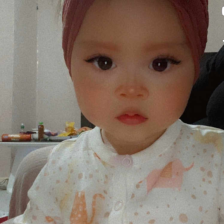 Maryam is registered to the contest to win money with this photo: accessories, baby, blouse, bonnet, clothing, couch, doll, dress, face, formalwear, furniture, hat, head, headband, homedecor, person, photography, portrait, tie, toy