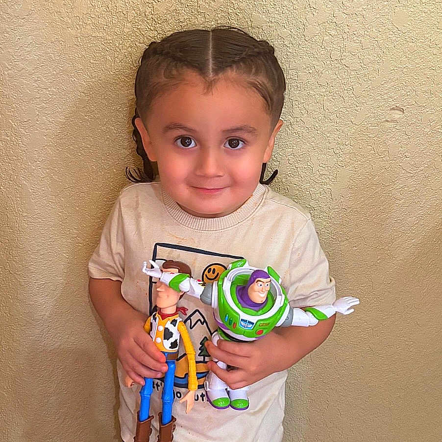 Ishamel Orta joined the competition — help win amazing prizes! action_figures, braids, buzz_lightyear, child, facial_expression, floor, full_body, happy, indoor, portrait, shorts, smiling, standing, t_shirt, toddler, toy_story, toys, wall, wood_floor, woody