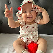 Olivia is registered to the contest to win money with this photo: baby, babylaughing, bodypart, bonnet, cap, clothing, face, finger, hand, happy, hat, head, hosiery, person, photography, portrait, sitting, smile, sock, wrist