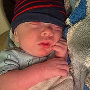 Cyrus is registered to the contest to win money with this photo: baby, sleeping, infant, blanket, hat, beanie, hand, cozy, closeup, face, skin, peaceful, cute, child, newborn, resting, soft, indoors, warm, portrait