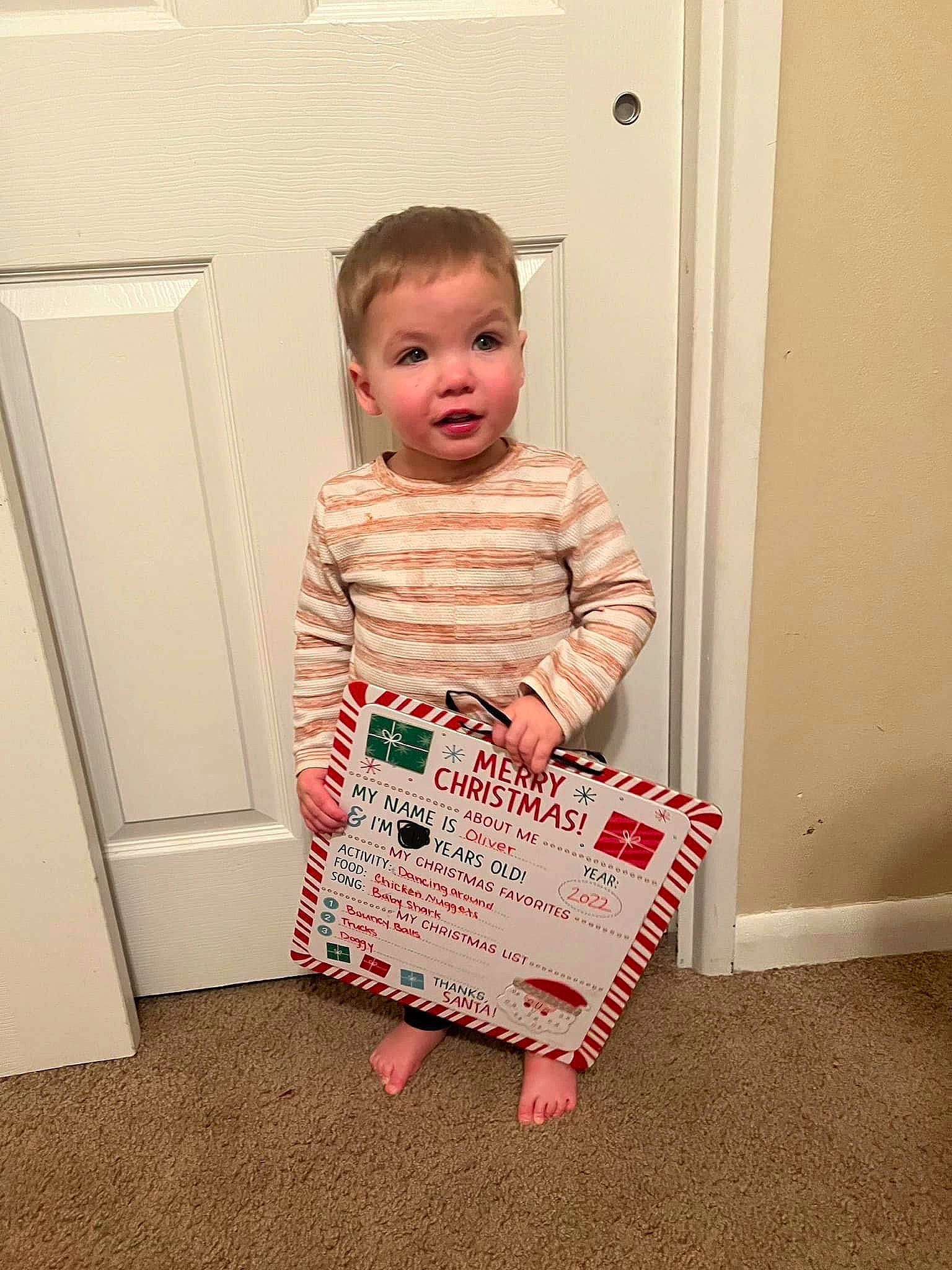 Oliver joined the competition — help win amazing prizes! baby, baby_toddler_clothing, carmine, child, door, dress, face, flooring, happy, hardwood, one_piece_garment, pattern, peach, person, pink, room, sitting, sleeve, t_shirt, toddler