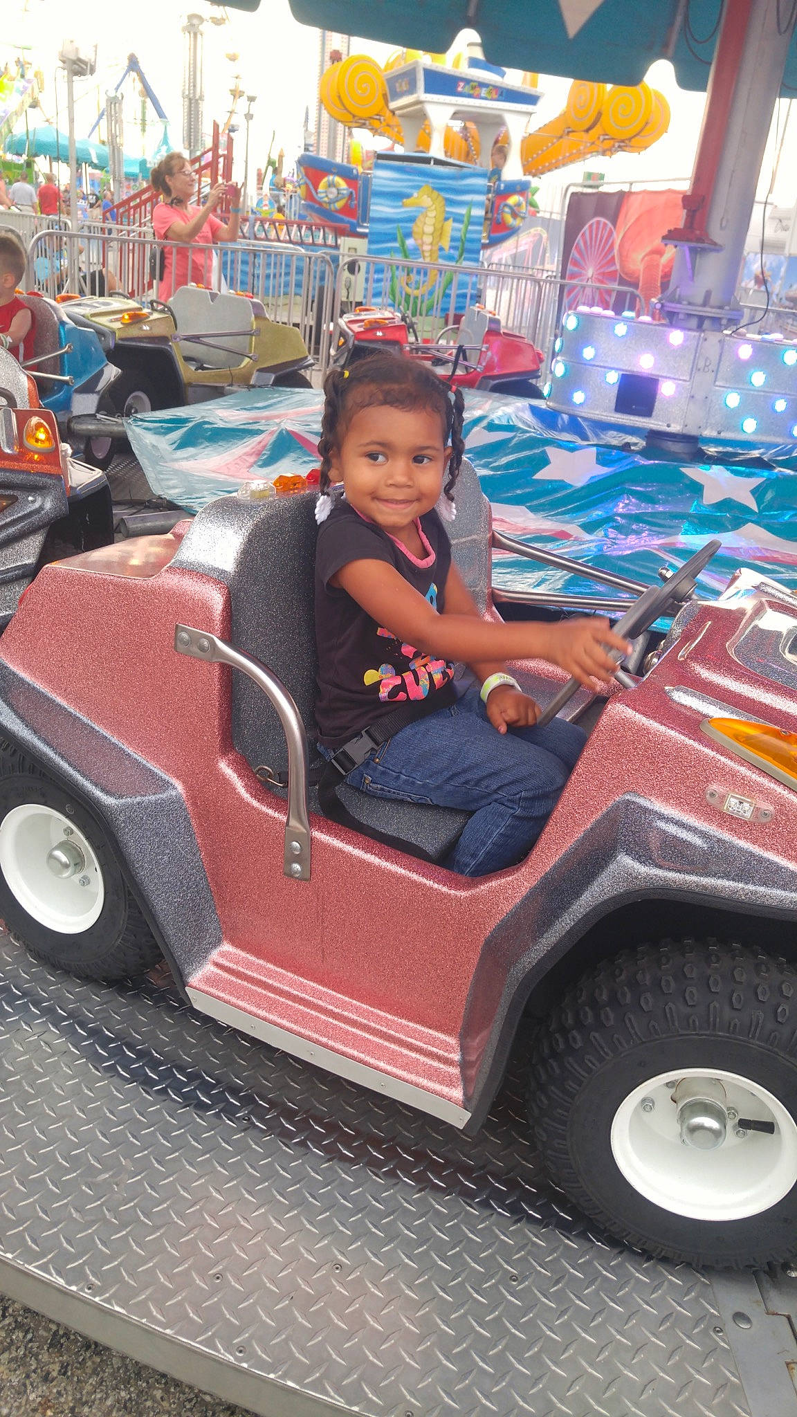 Heaven-leigh is registered to the contest to win money with this photo: amusement_park, amusement_ride, auto_part, automotive_exterior, car, child, fair, fun, joy, leisure, motor_vehicle, person, play, recreation, toddler, vacation, vehicle