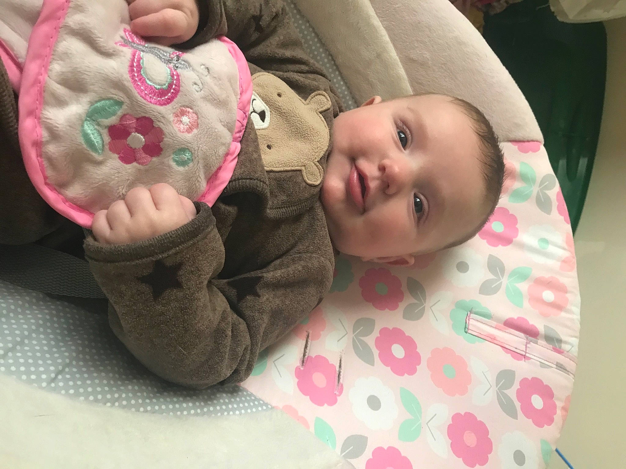 Raya is registered to the contest to win money with this photo: baby, baby_products, baby_toddler_clothing, cheek, child, comfort, flooring, hand, linens, lip, mouth, nose, pattern, person, pink, sitting, skin, sleeve, smile, textile