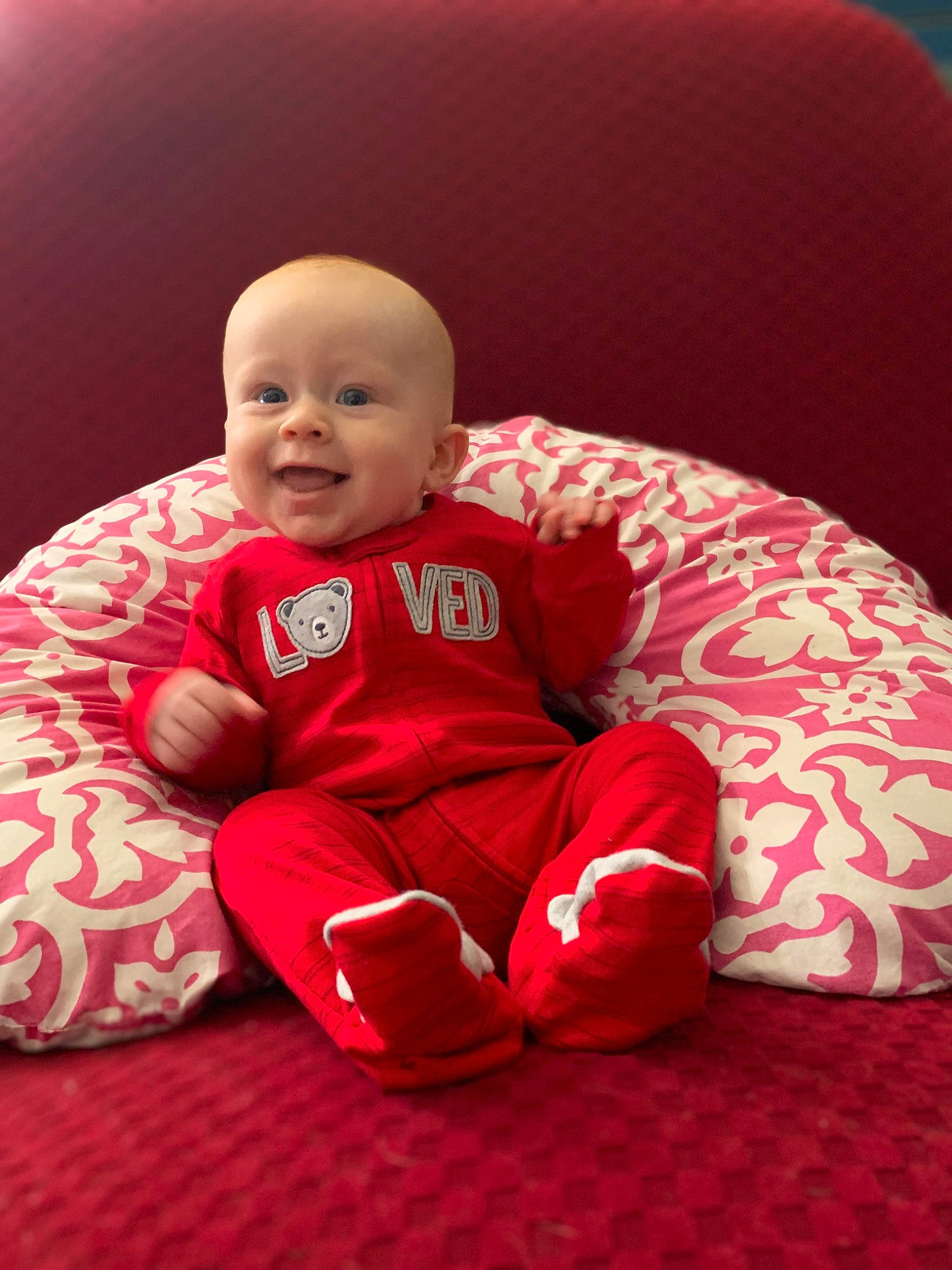 Dean is registered to the contest to win money with this photo: baby, baby_toddler_clothing, cheek, comfort, eye, face, facial_expression, flooring, happy, head, knee, leg, lip, mouth, outerwear, person, pink, skin, sleeve, smile