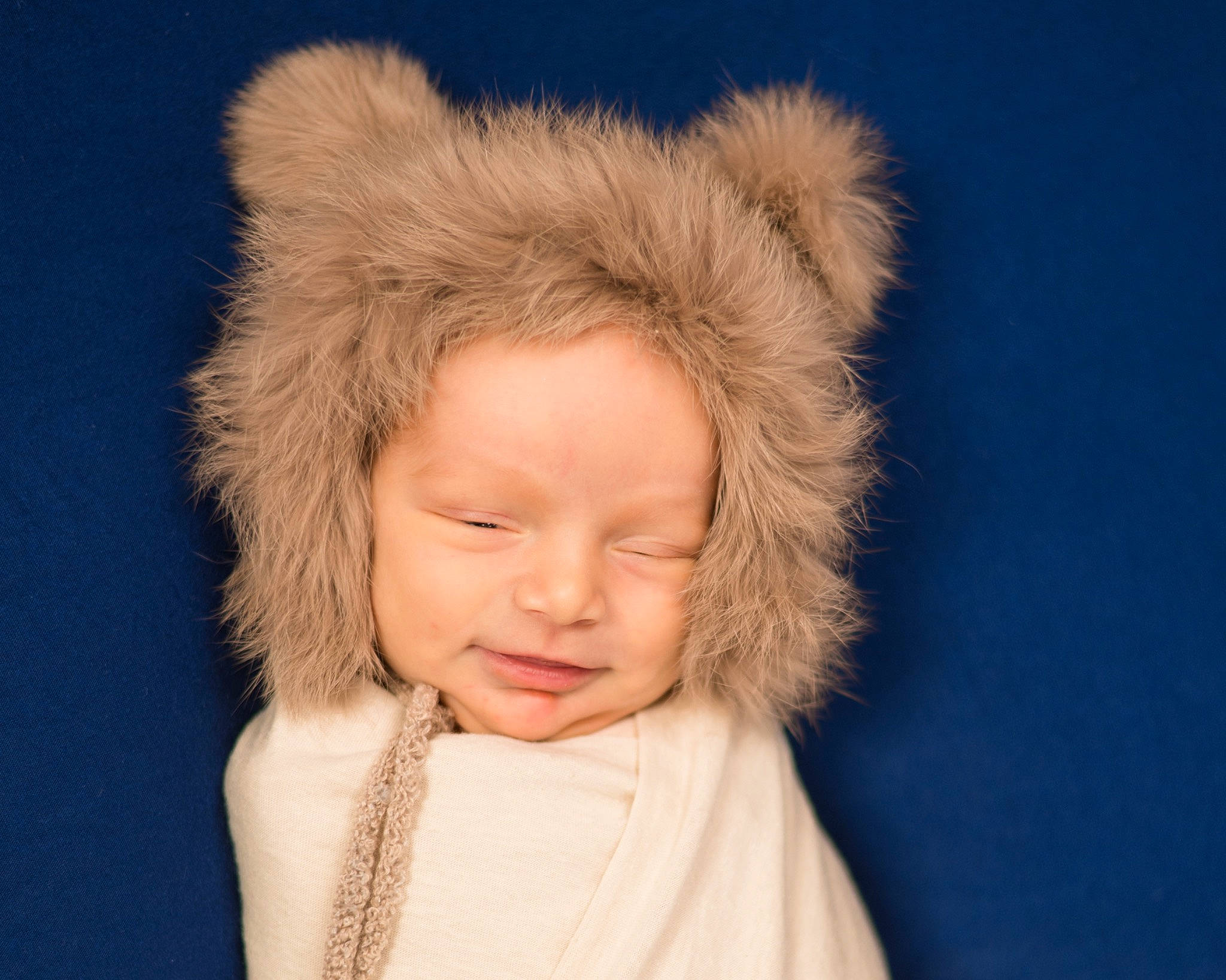 Hagen is registered to the contest to win money with this photo: animal_product, baby, baby_toddler_clothing, child, costume_hat, fashion_accessory, fun, fur, fur_clothing, hair, hair_accessory, happy, hat, headgear, headpiece, natural_material, person, sleeve, smile, toddler