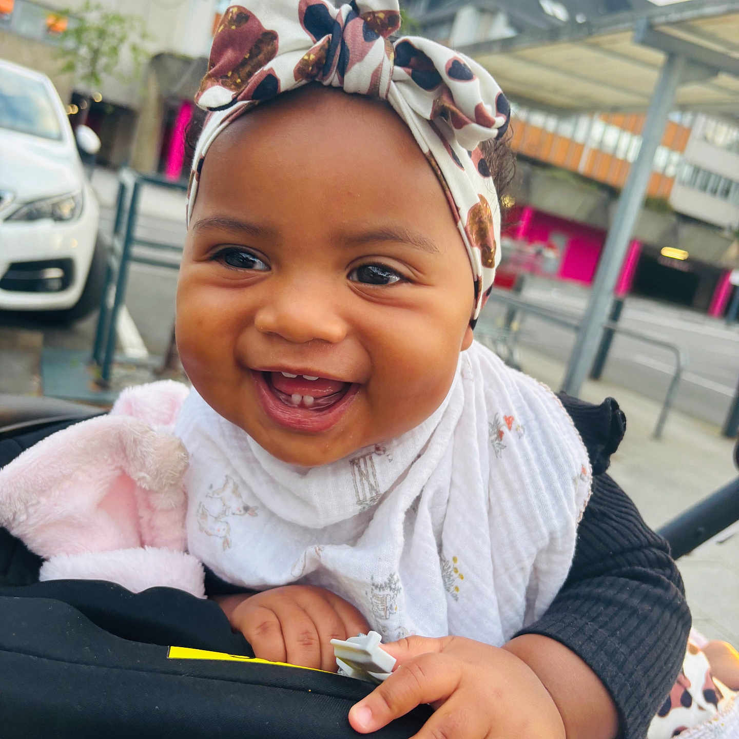 Thaissya a rejoint le concours — aidez-le/la à gagner de superbes lots ! baby, bib, building, car, child, clothing, cute, daylight, expression, face, hands, happy, headband, infant, outdoor, person, portrait, smiling, stroller, urban