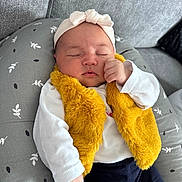 Zeïna participe au concours pour gagner de l'argent avec cette photo : baby, casual_clothing, child, cozy, cushion, cute, gray_couch, headband, home, indoor, infant, knotted_headband, peaceful, portrait, relaxed, resting, sleeping, soft_texture, white_shirt, yellow_vest