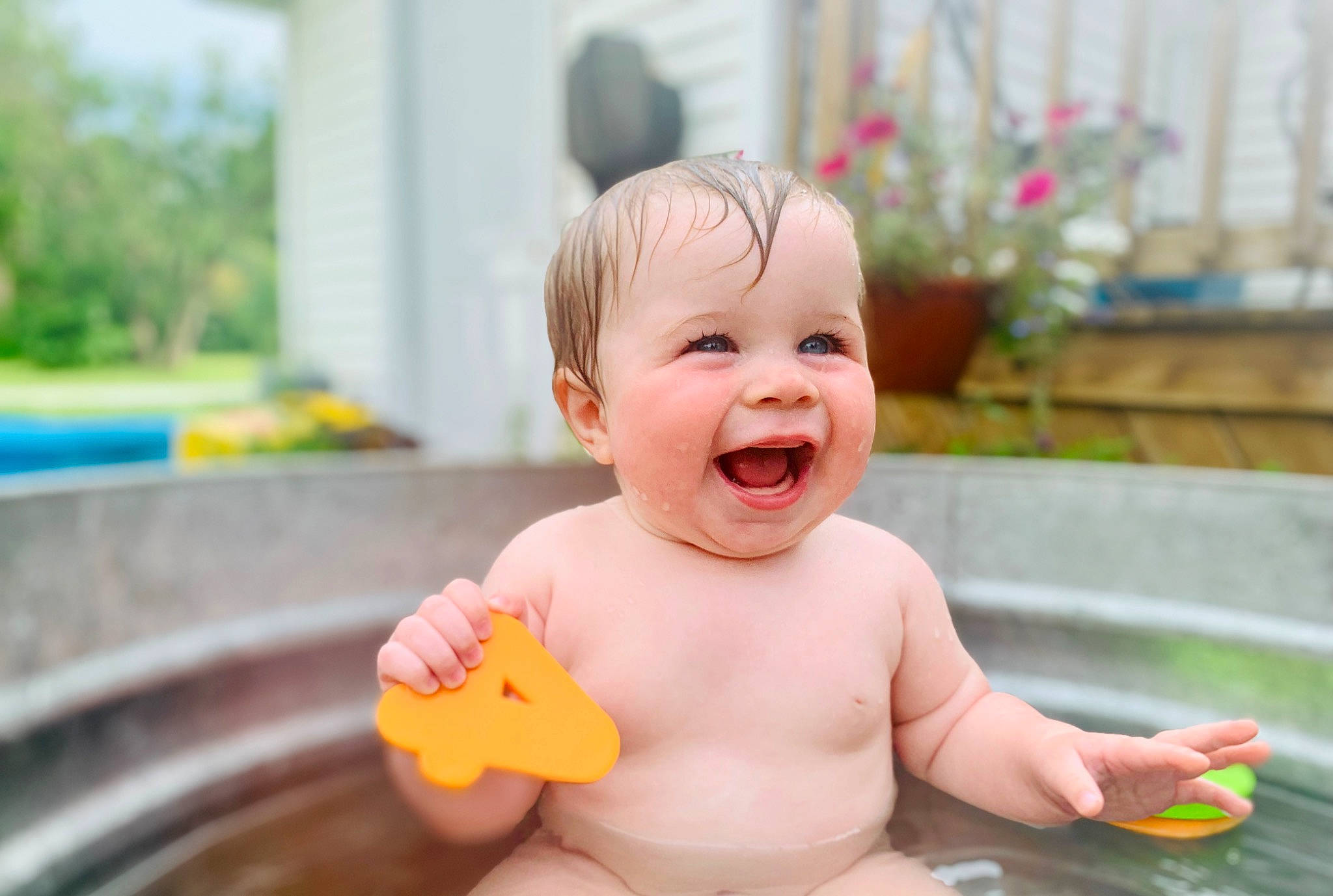 Evelyn is registered to the contest to win money with this photo: baby, baby_playing_with_toys, baby_toddler_clothing, cheek, child, finger, fun, green, happy, head, leisure, mouth, person, photograph, pink, plant, recreation, skin, smile, thumb