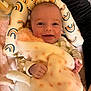 Charlotte is registered to the contest to win money with this photo: baby, blanket, smiling, face, infant, pillow, plush, pattern, hand, happy, soft, cozy, child, bed, fabric, cute, comfort, person, resting, indoors