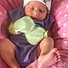 Elena is registered to the contest to win money with this photo: baby, newborn, infant, sleeping, hat, mittens, blanket, pink, purple_clothing, feet, toes, soft_texture, cute, peaceful, resting, person, indoors, cozy, headwear, closeup