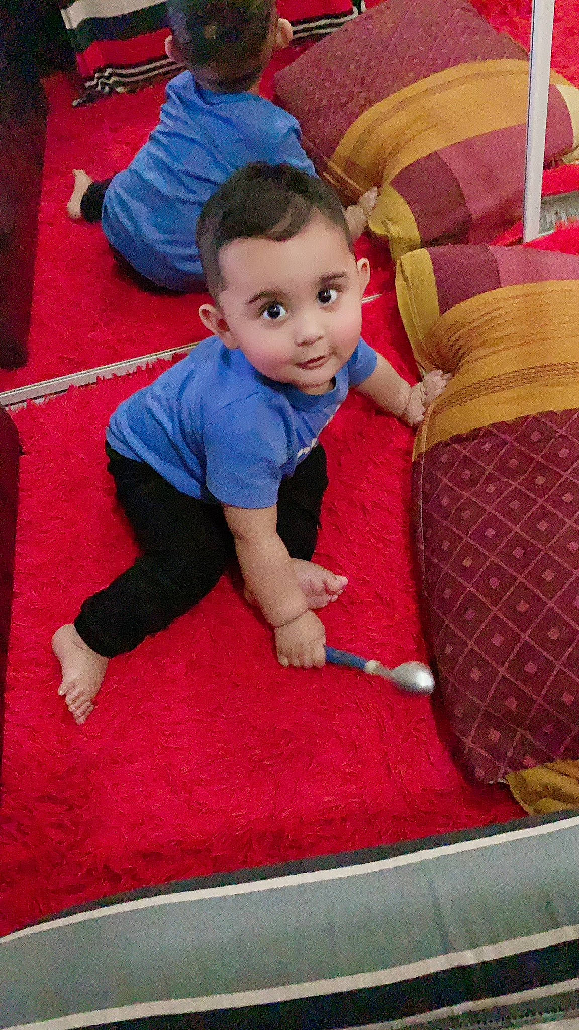 Shazil is registered to the contest to win money with this photo: baby, baby_toddler_clothing, carpet, child, comfort, floor, flooring, fun, grass, head, lap, leisure, person, play, recreation, red, room, sitting, smile, t_shirt