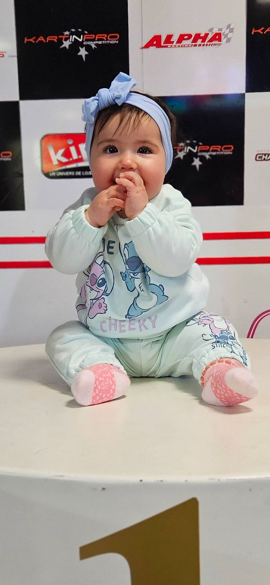 Mencïa a rejoint le concours — aidez-le/la à gagner de superbes lots ! baby, baby_toddler_clothing, cap, carmine, cheek, child, face, flooring, foot, fun, happy, headwear, kneeling, pattern, person, pink, room, sitting, skin, sleeve