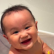 Lucas is registered to the contest to win money with this photo: baby, smile, bathtub, water, wet_hair, toy, child, happy, face, skin, hand, play, bath_time, cute, indoors, infant, person, expression, closeup, joy