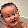 baby, smile, bathtub, water, wet_hair, toy, child, happy, face, skin, hand, play, bath_time, cute, indoors, infant, person, expression, closeup, joy