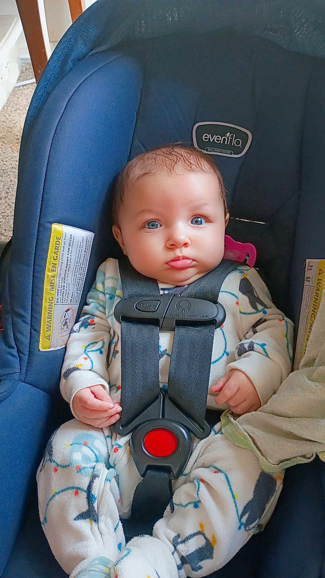 Mireyah is registered to the contest to win money with this photo: baby, infant, car_seat, blue_eyes, onesie, straps, pacifier, blanket, child, seatbelt, indoor, cute, face, hands, clothing, person, sitting, car_safety, young_child, portrait