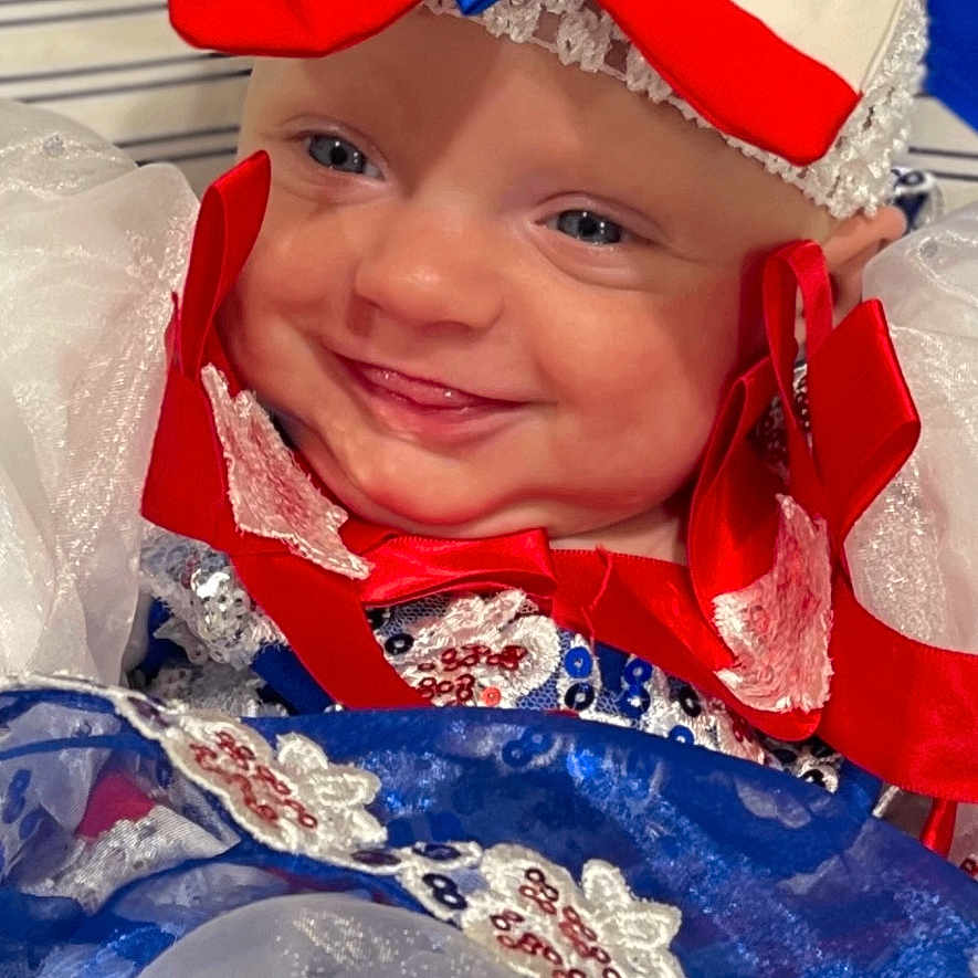 Audriana joined the competition — help win amazing prizes! baby, blue, bow, celebration, child, cute, dress, fabric, face, festive, happy, headband, indoor, lace, person, portrait, red, sequin, smile, white