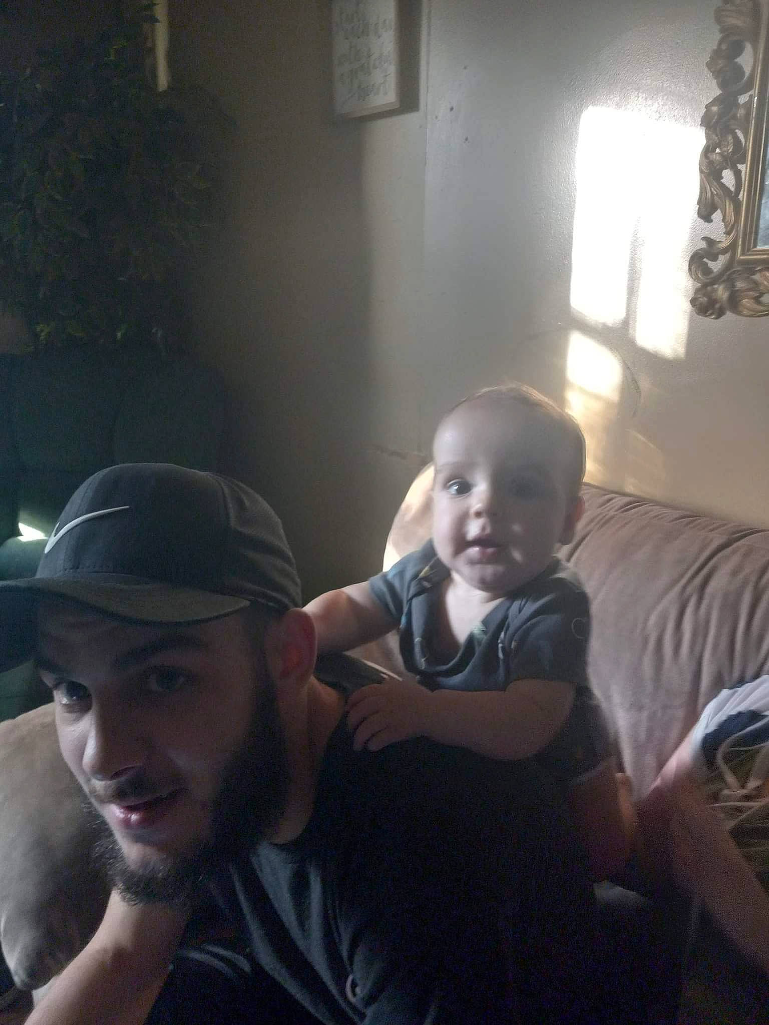 Maximus joined the competition — help win amazing prizes! arm, baby, baseball_cap, beard, cap, comfort, electronic_device, flash_photography, flooring, fun, happy, hat, headwear, interaction, person, picture_frame, shoulder, sitting, smile, t_shirt