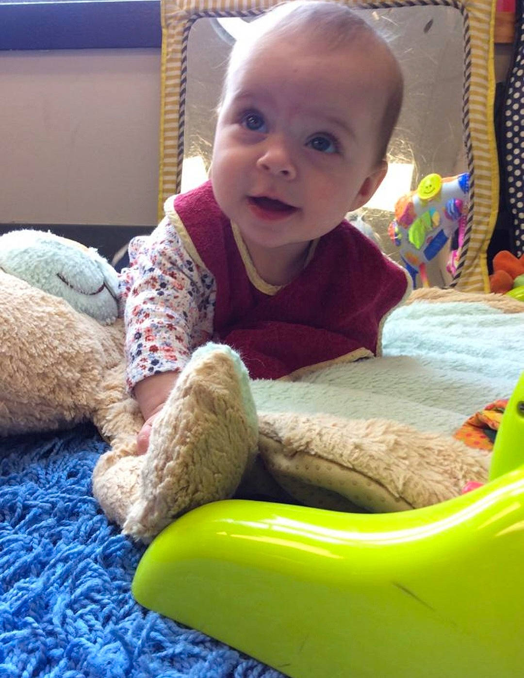 Leighton is registered to the contest to win money with this photo: baby, baby_playing_with_toys, baby_toddler_clothing, cheek, child, comfort, face, flooring, foot, fun, grass, head, human_body, human_leg, person, product, sitting, smile, sock, toddler
