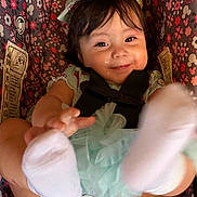 Mia is registered to the contest to win money with this photo: baby, child, smiling, headband, socks, car_seat, floral_pattern, cute, happy, infant, clothing, toddler, playful, face, person, young_child, indoors, portrait, seatbelt, colorful