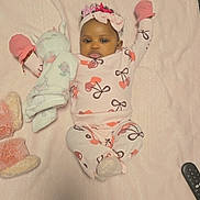 Kilaize is registered to the contest to win money with this photo: baby, infant, child, portrait, lying_down, blanket, pink, pajamas, mittens, headband, bow_pattern, stuffed_animal, bunny, smiling, indoors, bed, cozy, remote_control, toy, photography