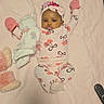 baby, infant, child, portrait, lying_down, blanket, pink, pajamas, mittens, headband, bow_pattern, stuffed_animal, bunny, smiling, indoors, bed, cozy, remote_control, toy, photography