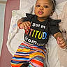 baby, child, infant, smiling, portrait, sitting, hospital, chair, blanket, headband, flower, black_shirt, rainbow_pants, striped_clothing, sneakers, fashion, colorful, outdoorless, cables, happy