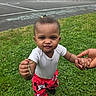 baby, child, toddler, outdoor, grass, park, basketball_court, basketball_hoop, camper, portrait, standing, smiling, pouting, facial_expression, hands, adult_hand, white_shirt, red_pants, minnie_mouse, grass_blade