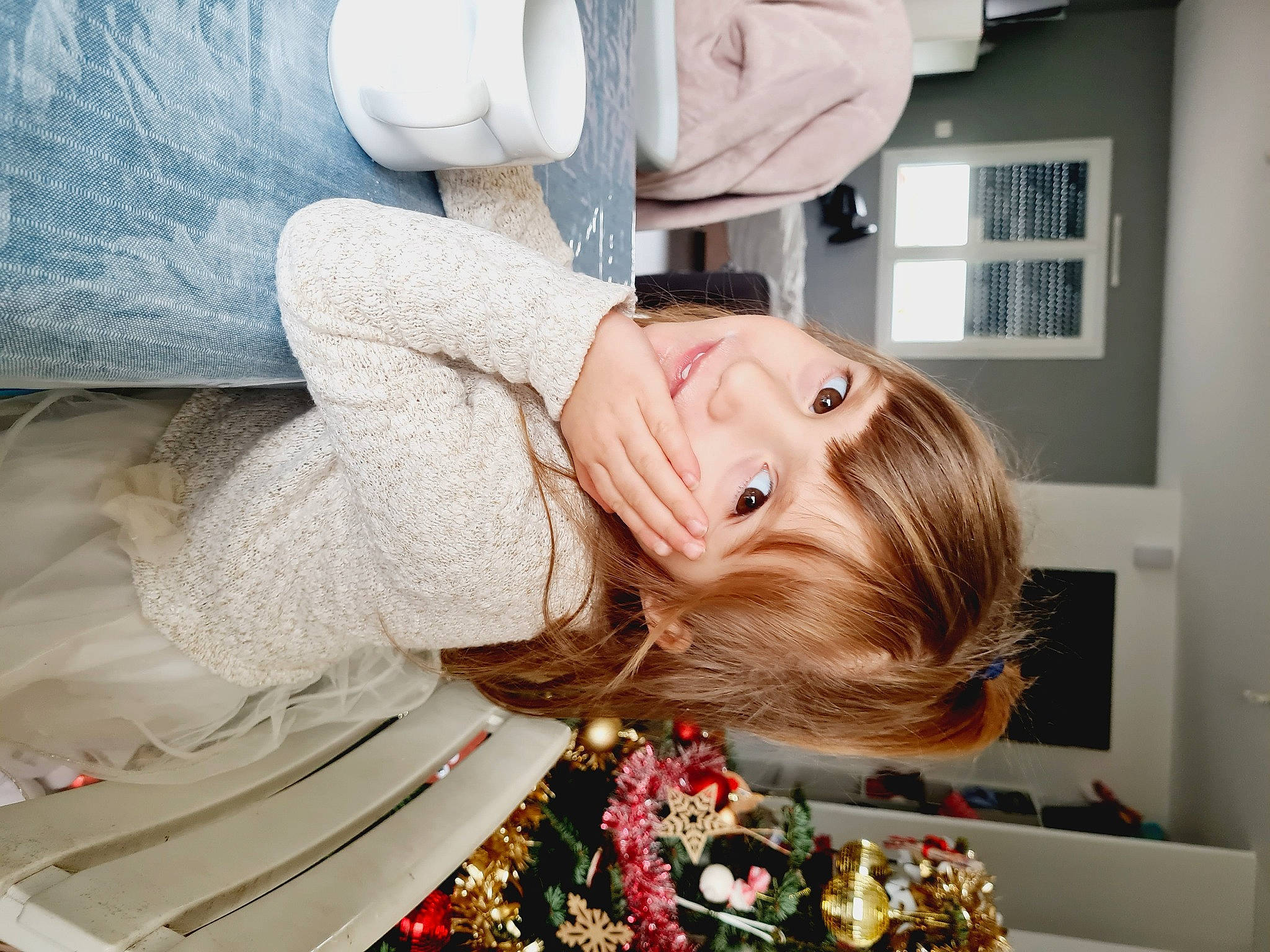 Cyrielle participe au concours pour gagner de l'argent avec cette photo : blond, brown_hair, child, comfort, facial_expression, fun, fur, hair, happy, human_body, long_hair, person, portrait_photography, room, sitting, tree, window, wood