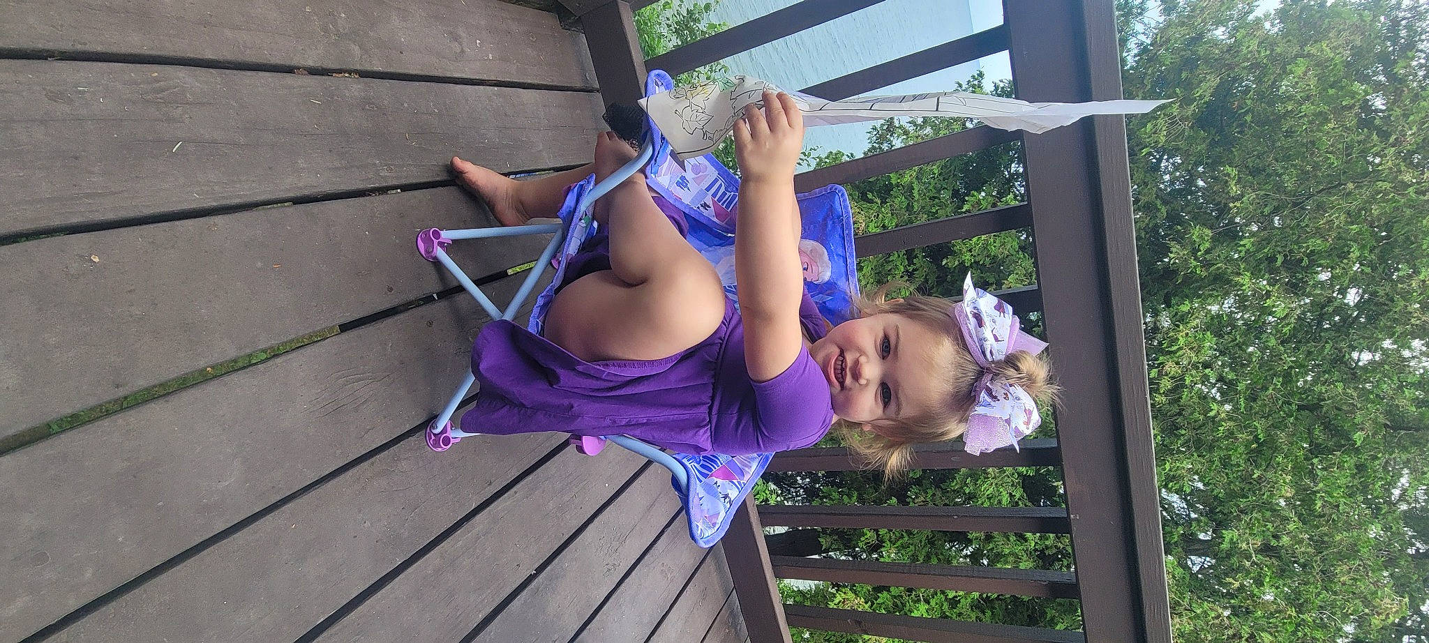 Mariella is registered to the contest to win money with this photo: blue, child, electric_blue, grass, happy, human_leg, leisure, magenta, outdoor_play_equipment, person, pink, plant, purple, recreation, smile, swing, thigh, toddler, tree, violet