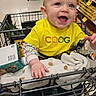 baby, child, shopping_cart, supermarket, smiling, yellow_shirt, grocery_store, happy, infant, clothing, person, aisle, retail, cute, retail_shelves, baby_in_cart, baby_clothing, shopping, store, toddler