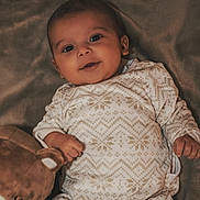 Kemys participe au concours pour gagner de l'argent avec cette photo : baby, infant, smiling, onesie, blanket, plush_toy, teddy_bear, cozy, cute, child, portrait, indoors, soft_lighting, happy, lying_down, patterned_clothing, young, peaceful, closeup, warm